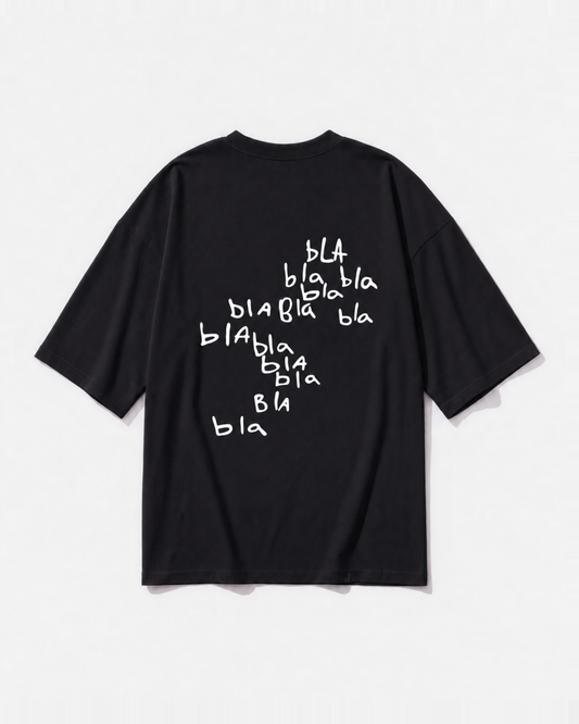 Scribbled 'bla bla bla' graphic printed across the back of a black oversized t-shirt by Dear India