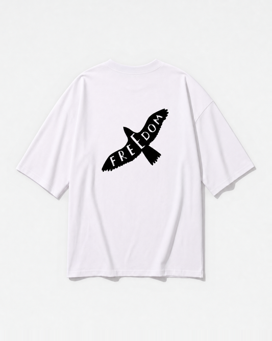 A bird in flight with FREEDOM lettered into its wings printed across the back of a white oversized t-shirt by Dear India