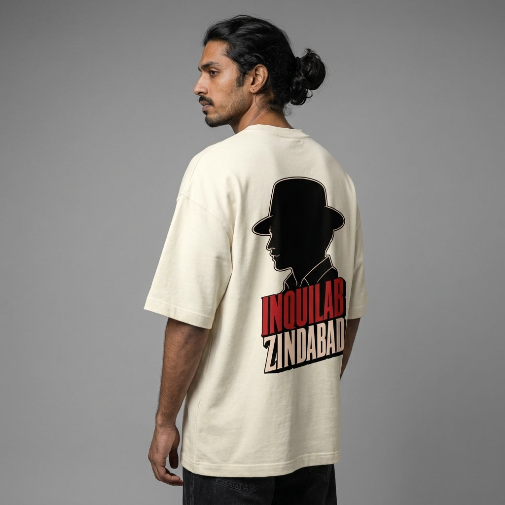 Person wearing a beige t-shirt with a silhouette design and text on the back, against a gray background