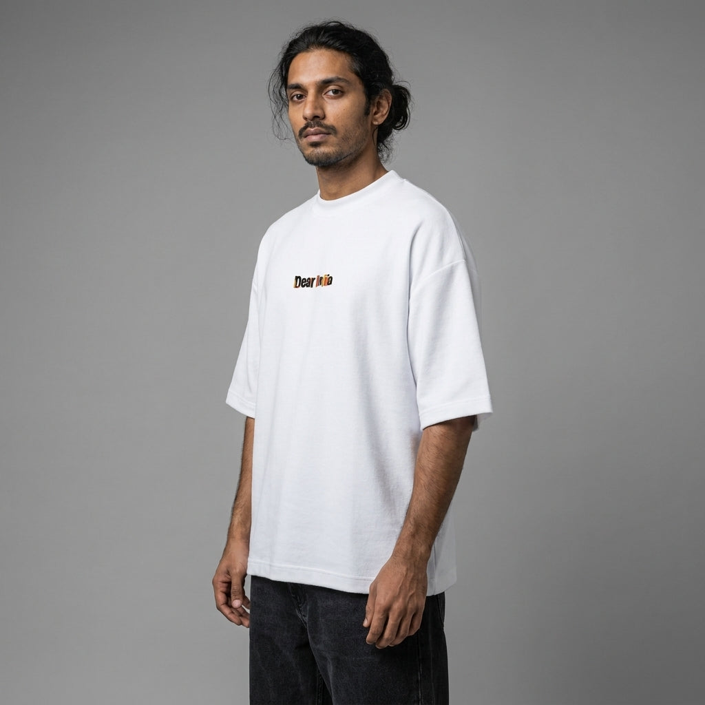 Man wearing a white t-shirt with a logo on a gray background