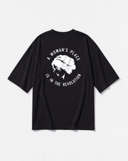 A woman's place statement graphic printed across the back of a black oversized t-shirt by Dear India